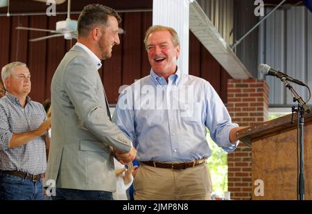 Fancy Farm, Kentucky, États-Unis. 06 août 2022. Steven Elder (au centre), organisateur de pique-nique, remet le microphone au maître de cérémonie David Osborne, président de la Chambre des représentants de l'État, comme le congressiste James Comer (à gauche) regarde pendant le pique-nique de la ferme de Saint-Jérôme de 142nd. Collecteur de fonds pour l'église catholique Saint-Jérôme, le pique-nique est connu pour servir des tonnes de viandes grillées et pour inviter les politiciens à jouer les uns aux autres devant une foule qui est à la fois autorisée et encouragée à chatouiller. (Crédit: Billy Suratt/Apex MediaWire via Alay Live News) Banque D'Images