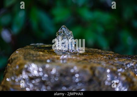 L'eau gelée en mouvement se précipite hors d'une pierre à eau Banque D'Images