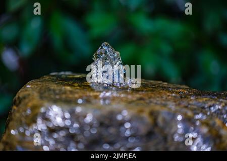 L'eau gelée en mouvement se précipite hors d'une pierre à eau Banque D'Images