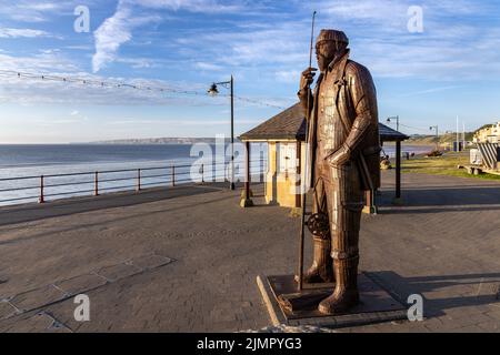 Un haut Tide en courtes bottes, une sculpture de Ray Lonsdale d'un pêcheur qui se dresse haut et fier sur la promenade de Filey, North Yorkshire. Banque D'Images