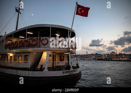 Istanbul, Turquie. 06th août 2022. Le ferry des lignes de la ville s'est arrêté à l'embarcadère de Karakoy et au pont historique de Galata en arrière-plan. Crédit : SOPA Images Limited/Alamy Live News Banque D'Images