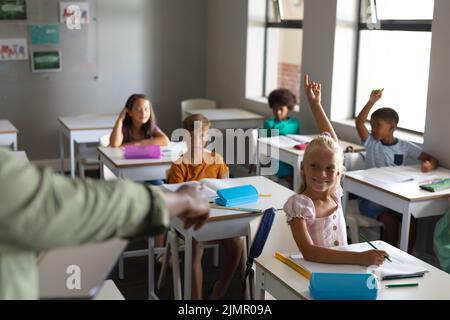 Main courte d'un jeune enseignant afro-américain pointant vers une écolière de race blanche avec la main levée Banque D'Images