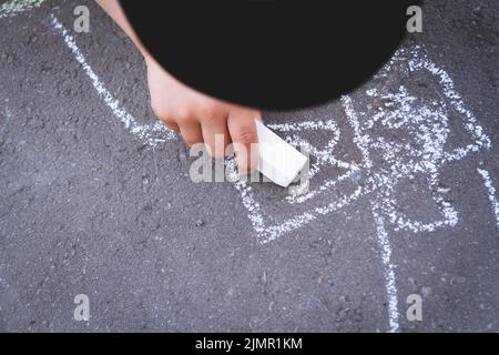 Les enfants s'attirent avec de la craie sur la route. Créativité des enfants dans la rue. Banque D'Images