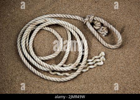 Ancienne corde sur une plage côtière sablonneuse Banque D'Images