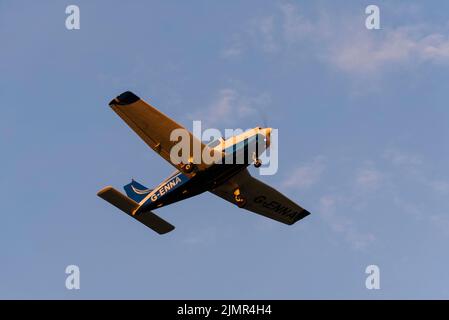 Piper PA-28-161 Cherokee Warrior II de Falcon Flying Services décollage à l'aéroport Southend de Londres, Essex, Royaume-Uni. Escalade vers le coucher du soleil, rouge éclatant Banque D'Images