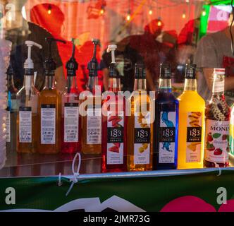 Bouteilles de sirop colorées, rouge et jaune différents types de sirops dans des pots en verre avec le observateur. Personne, affaires de nourriture et de boissons-31 juillet,2022-Richmo Banque D'Images