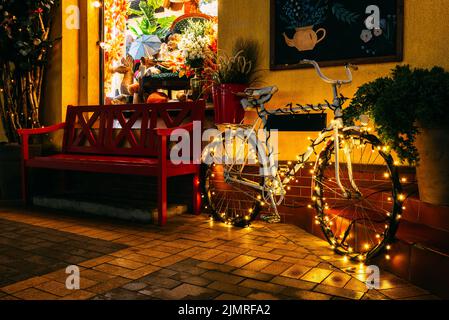 Un vélo décoré pour les vacances de Noël dans une rue nocturne. Banque D'Images
