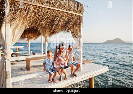 Mère avec trois enfants sur la Turquie Resort bungalow assis contre la mer Méditerranée. Banque D'Images