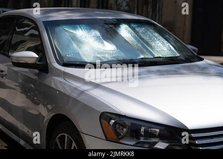 Surface réfléchissante protectrice sous le pare-brise de la voiture par temps chaud, chauffée par les rayons du soleil à l'intérieur de la voiture Banque D'Images