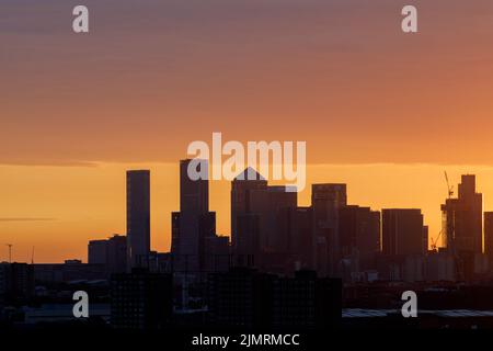 Londres, Royaume-Uni-29,7.22: La silhouette du quartier central des affaires de Canary Wharf au lever du soleil, vue de Southwark. Situé sur l'île des chiens Banque D'Images