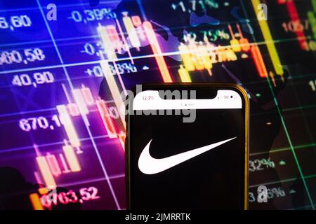 KONSKIE, POLOGNE - 07 août 2022 : smartphone affichant le logo de Nike Inc sur fond de diagramme de la Bourse Banque D'Images