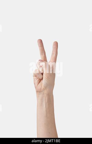 Compter sur les doigts main femelle, deux ou lettre V sur blanc. Banque D'Images