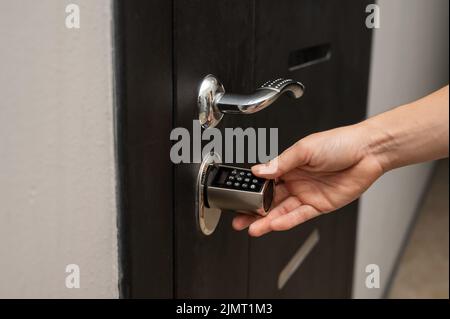 Femme ouvre la serrure à combinaison sur la porte de l'appartement. Entrée sans clé. Banque D'Images