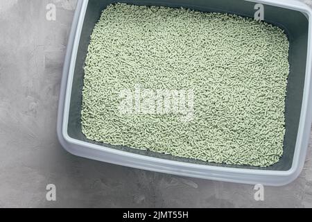 Boîte à litière pour chats avec litière en tofu biodégradable et lavable naturel et parfum de poudre de thé vert. Produit écologique pour animaux domestiques. Vue de dessus, espace de copie Banque D'Images
