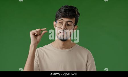 Déçu brunette arabian man faire un petit geste avec les doigts mécontent gars montrer petite taille forme basse évaluation mesure pouce minuscule Banque D'Images