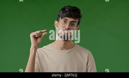 Déçu brunette arabian man faire un petit geste avec les doigts mécontent gars montrer petite taille forme basse évaluation mesure pouce minuscule Banque D'Images
