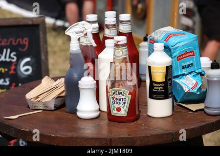 Une charge de condiments sur une table dans un café à Chichester, West Sussex, Royaume-Uni. Banque D'Images