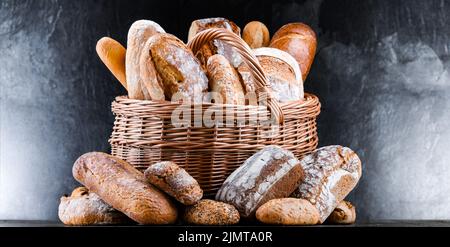 Panier en osier avec assortiment de produits de boulangerie, dont des pains et des petits pains Banque D'Images