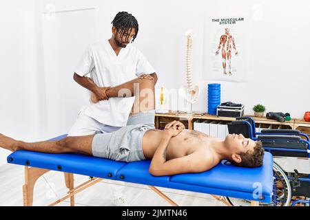 Deux hommes physiothérapeute et patient ayant la session de réadaptation étirant la jambe à la clinique Banque D'Images