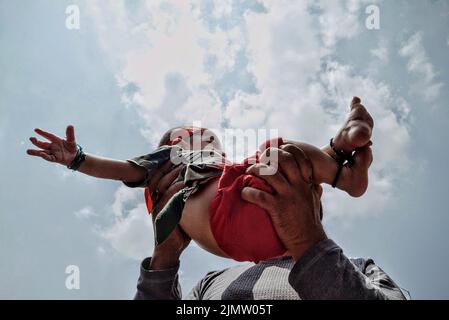 Srinagar, Inde. 08th août 2022. Un père lève son fils de 6th mois dans l'air comme marque de protestation contre la décision de l'Inde d'interdire 8th processions de Muharram à Srinagar, Cachemire, Inde, sur 7 août 2022. (Photo de Hassnain Riza/Sipa USA) crédit: SIPA USA/Alay Live News Banque D'Images