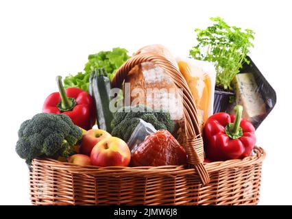 Panier en osier avec assortiment de produits d'épicerie isolés sur fond blanc Banque D'Images