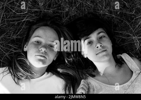 Deux filles couchée sur l'herbe. Portrait noir et blanc . Banque D'Images