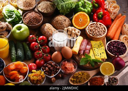 La composition avec un assortiment de produits alimentaires biologiques sur table de cuisine en bois. Banque D'Images