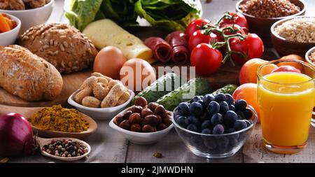 La composition avec un assortiment de produits alimentaires biologiques sur table de cuisine en bois. Banque D'Images