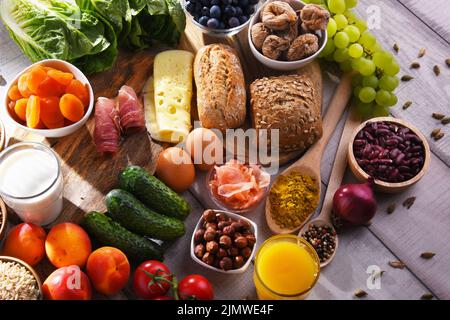 La composition avec un assortiment de produits alimentaires biologiques sur table de cuisine en bois. Banque D'Images