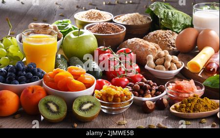 La composition avec un assortiment de produits alimentaires biologiques sur table de cuisine en bois. Banque D'Images