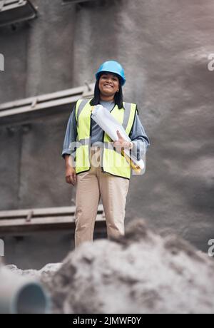 La gestion de son site professionnellement. Portrait court d'une jeune femme attirante travaillant sur le chantier. Banque D'Images