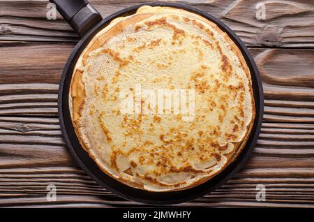 Pile de crêpes françaises dans une poêle sur une table de cuisine en bois Banque D'Images