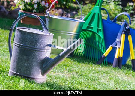Outils de jardinage sur l'herbe dans le jardin. Banque D'Images