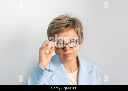 Portrait d'une femme d'affaires en costume bleu, lunettes. Banque D'Images