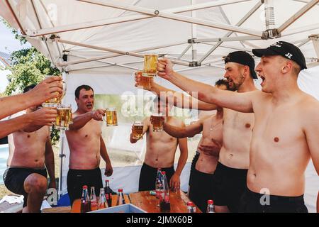 Horben, Allemagne. 17th juillet 2022. Les joueurs de fin de guerre de TC Feuerstein-Horben se toastent avec Radler après le tournoi. Selon la German Turf Sports and Tug-of-War Association (DRTV), il y a environ 600 à 700 athlètes actifs de tug-of-War dans tout le pays, la plupart dans le sud. Le remorqueur de guerre est considéré comme l'un des sports les plus anciens de tous : les peintures murales représentant les équipes de garçons tirant sur une corde sont connues aussi loin que l'Égypte ancienne. (Vers dpa ''Corope up!' - Le Tug de la guerre est plus qu'un simple test de la force') Credit: Philipp von Ditfurth/dpa/Alamy Live News Banque D'Images