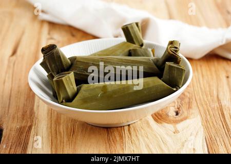 Lontong, gâteau au riz bouilli indonésien, gâteau au riz populaire indonésien enveloppé de feuilles de banane. Sur une table en bois Banque D'Images