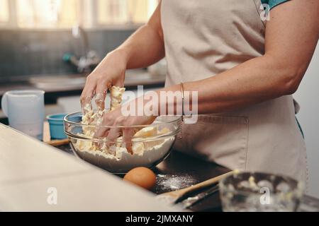 Mettez vos mains au travail. Une femme méconnaissable qui cuit à l'intérieur de sa cuisine à la maison. Banque D'Images