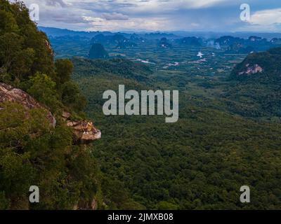 Dragon Crest Mountain Krabi Thailand, un jeune voyageur est assis sur un rocher qui surplombe les abysses, avec un paysage magnifique. Faites glisser Banque D'Images