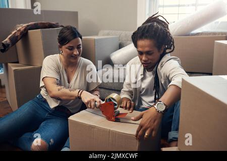 Celui-ci est prêt à partir. Un jeune couple qui porte des boîtes à la maison. Banque D'Images