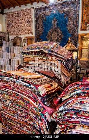 Grandes piles de tapis orientaux dans un magasin. Marché aux tapis colorés. Turquie Banque D'Images