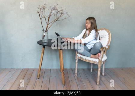 Jeune fille avec tablette regardant le webinaire en ligne, l'écoute de cours audio, le concept d'e-learning. Photo de haute qualité Banque D'Images