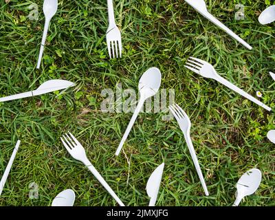 Couverts en plastique blanc, parc d'herbe verte Banque D'Images