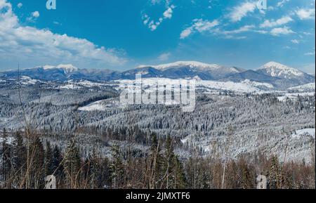 En hiver, les environs isolés des villages alpins, les collines de campagne, les bosquets et les terres agricoles offrent une vue depuis les pentes de montagne Banque D'Images