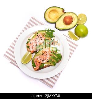 Toasts d'avocat, de saumon et de fromage à la crème fraîchement préparés, isolés sur fond blanc Banque D'Images