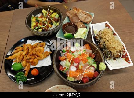 Kaisen don (bol de riz sashimi au poisson cru), crevettes frites, brochettes de porc au barbecue, Takoyaki (en-cas en forme de boule à base de farine de blé et de calmar) Banque D'Images