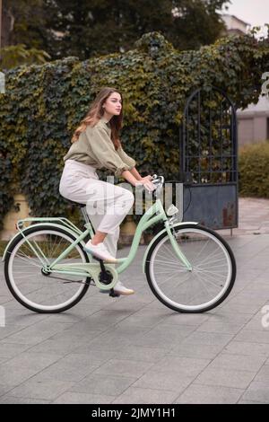 Vue latérale femme ville à vélo Banque D'Images