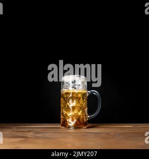 Tasse savoureuse de bière bavaroise avec fond noir Banque D'Images