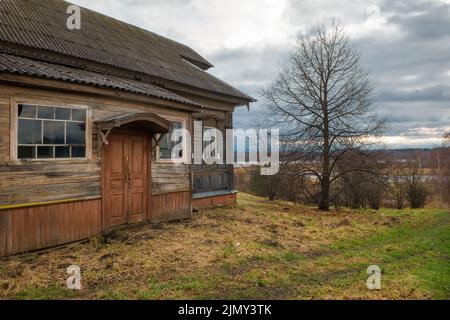 Maison abandonnée et jardin abandonné dans le village lors d'une journée nuageuse d'automne. Les pommes sont tspali des branches et reposent sur le sol Banque D'Images