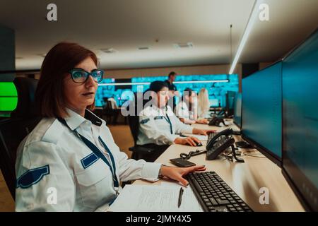 Groupe d'opérateurs de sécurité féminins travaillant dans une salle de contrôle de système de données opérateurs techniques travaillant sur un poste de travail avec multipl Banque D'Images