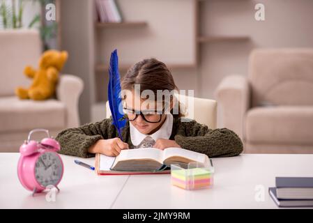 Jeune petite fille étudiant à la maison dans le concept de gestion du temps Banque D'Images